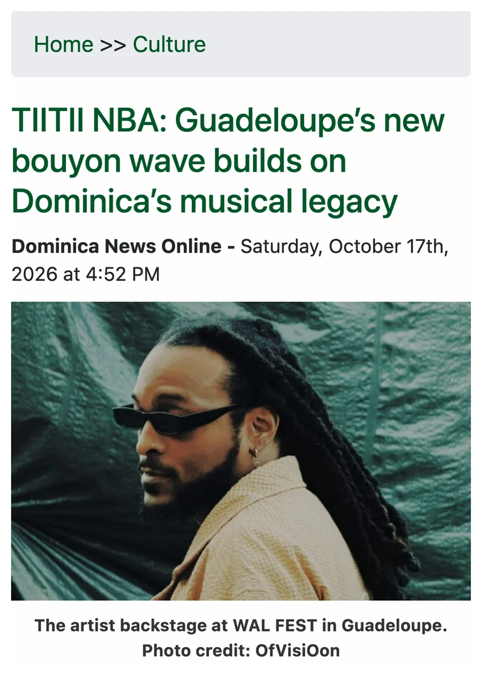Capture de l'article de Dominica News Online, rubrique Culture : titre « TIITII NBA: Guadeloupe's new bouyon wave builds on Dominica's musical legacy », daté du samedi 17 octobre 2026, avec une photo de TIITII NBA de profil, lunettes noires, devant une bâche verte